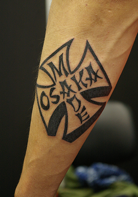 アイアンクロスと「OSAKA MADE」の文字のタトゥー Lucky Round Tattoo
